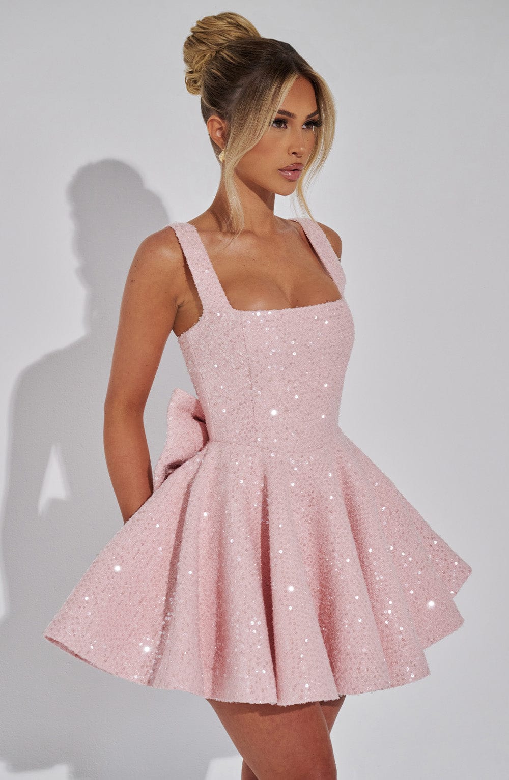 Women's formal pink sequin skater dress with bow, great for homecoming & dance events.