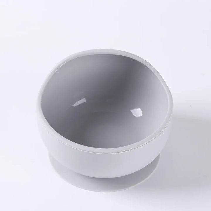 Ergonomic silicone suction bowl in teal, promoting self-feeding skills for babies.