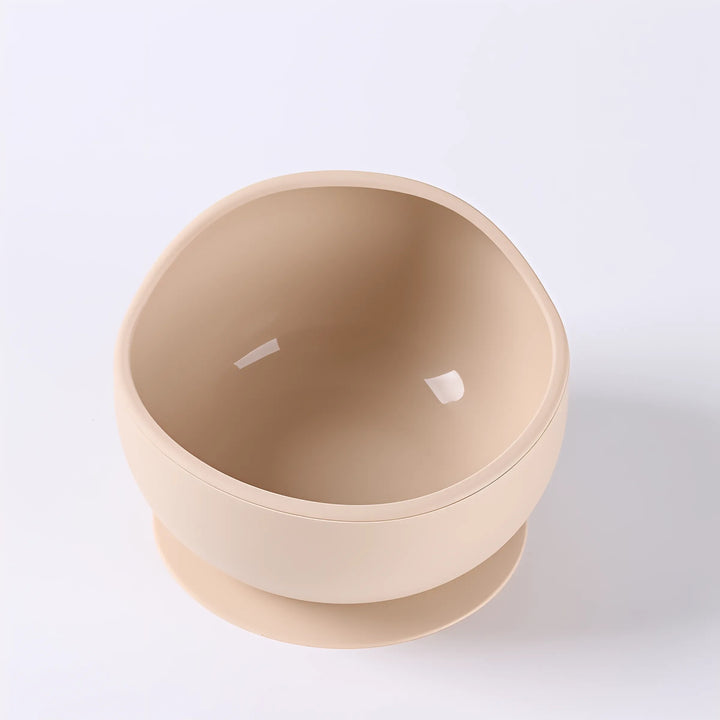 Hand holding a soft silicone suction bowl, demonstrating flexible, kid-safe material.