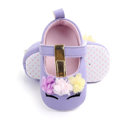 Close-up of girl's unicorn first walker shoes, floral accents, soft sole for early walking