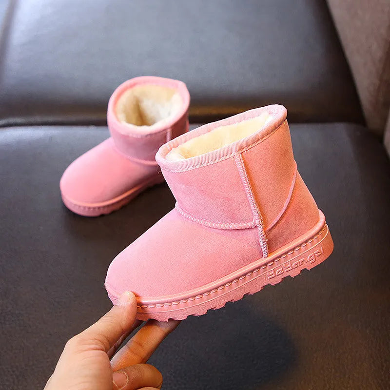 Child wearing blue cotton snow boots, playing happily in the snow, warm and comfortable.