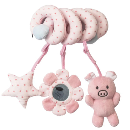 Infant reaching for the hanging plush animals on a spiral car seat and crib toy