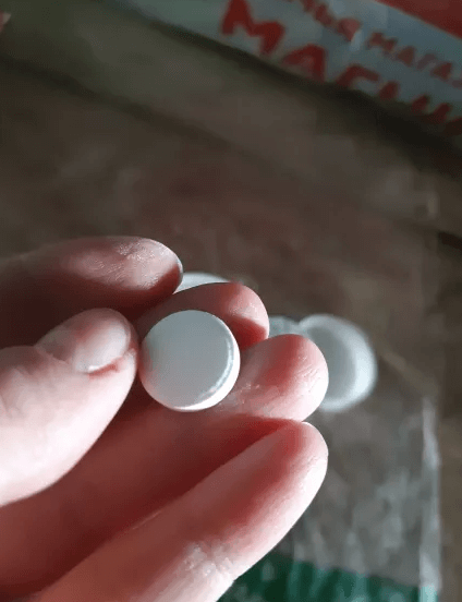 Hand dropping Pool & Spa Clarifying Tablets into water. Easy-to-use water treatment for clear pool & spa.