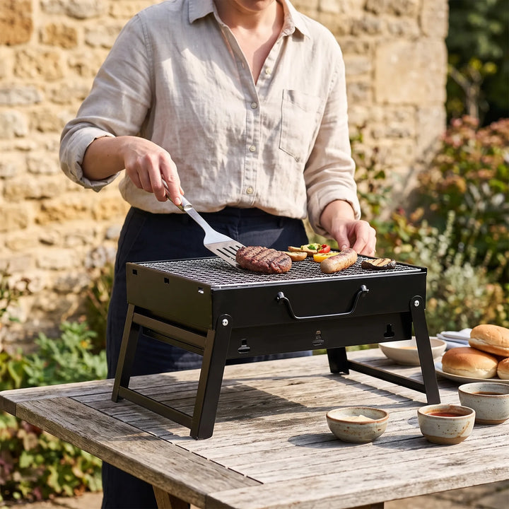 Portable charcoal grill for outdoor BBQ & camping. Compact folding design, easy to carry for picnics.