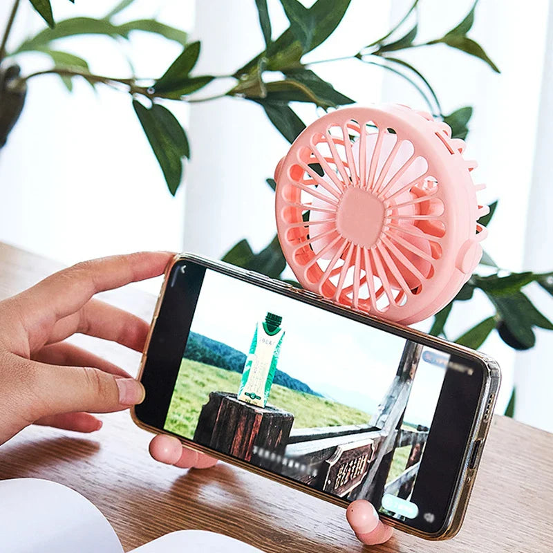 Portable clip-on fan attached to a baby crib railing, providing cool air for infants.