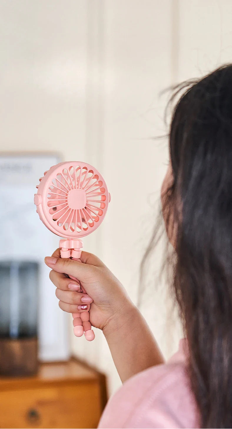 Clip-on personal fan, USB rechargeable, keeping a baby comfortable in a stroller during summer.