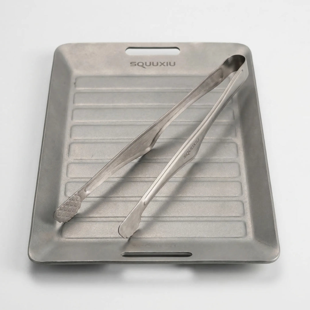 Compact portable ridged grill plate & tongs, designed for solo outdoor cooking & adventure meals while hiking.