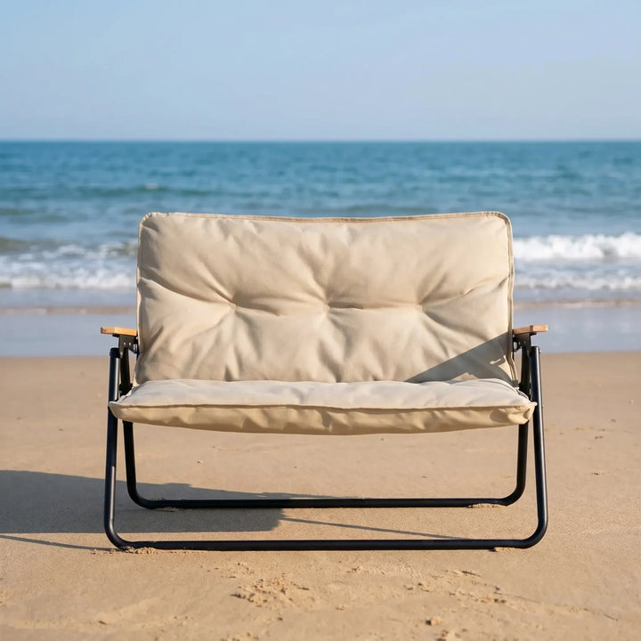Portable two-person folding camping sofa for comfortable outdoor seating at campsites or picnics.