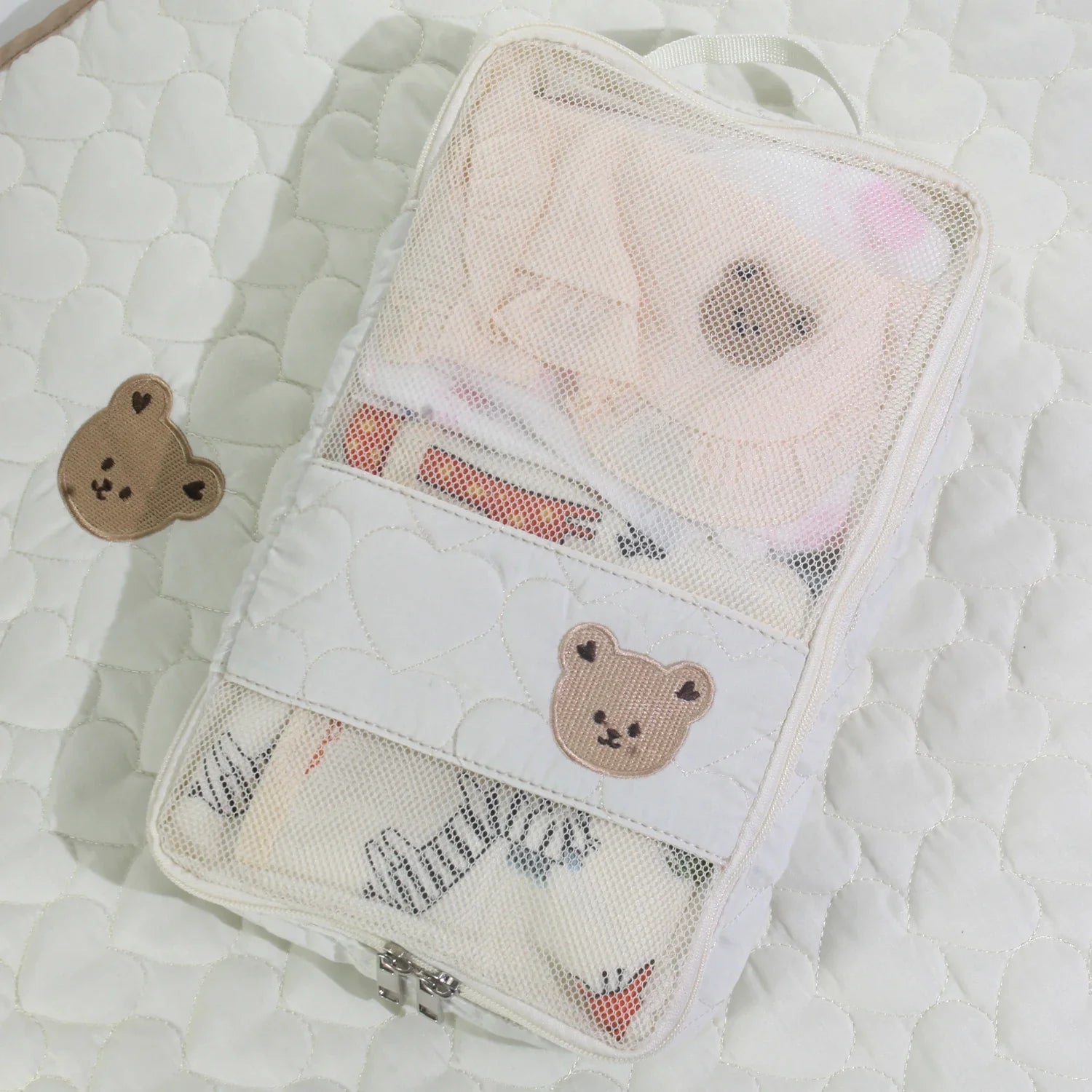 Open portable white bear diaper bag, showing spacious waterproof interior for baby items
