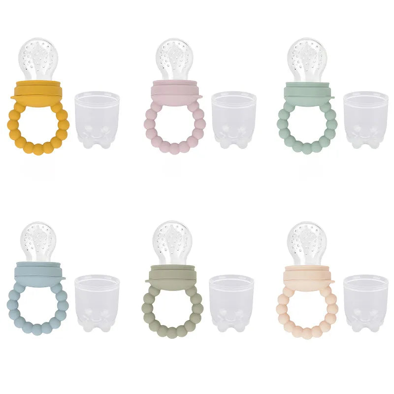Cute marketing shot of a baby fruit feeder pacifier next to fresh berries