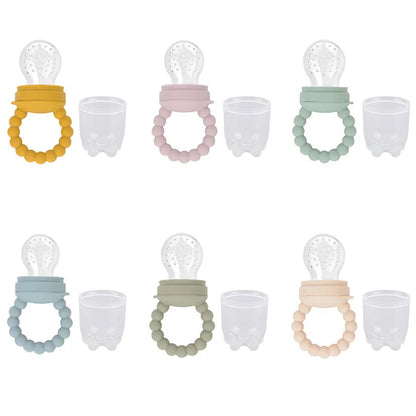Cute marketing shot of a baby fruit feeder pacifier next to fresh berries