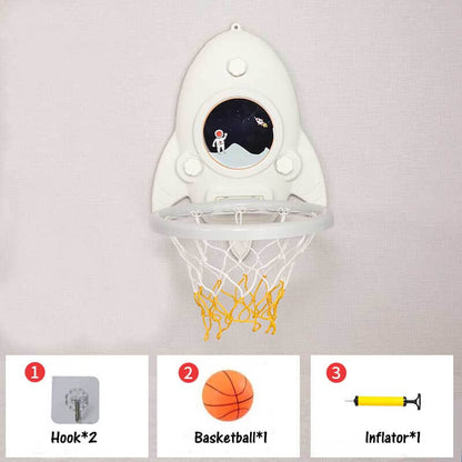 Child reaching for a wall-mounted red and blue mini basketball hoop, promoting active fun & sports skills.