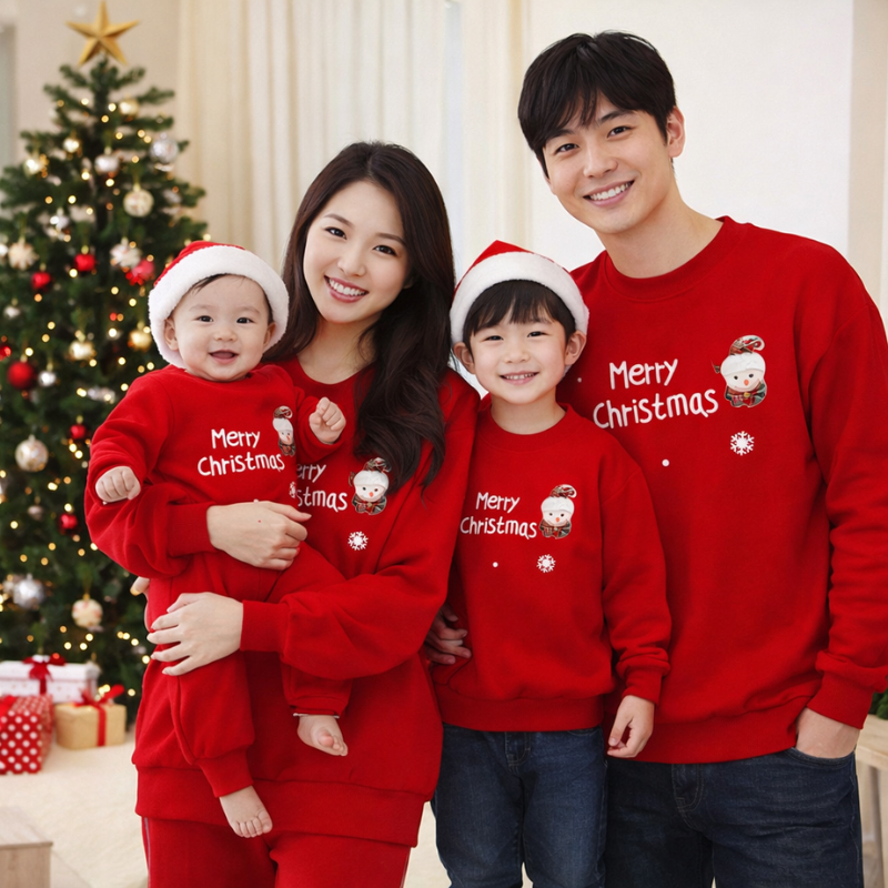 Family in matching red Christmas outfits with reindeer design.