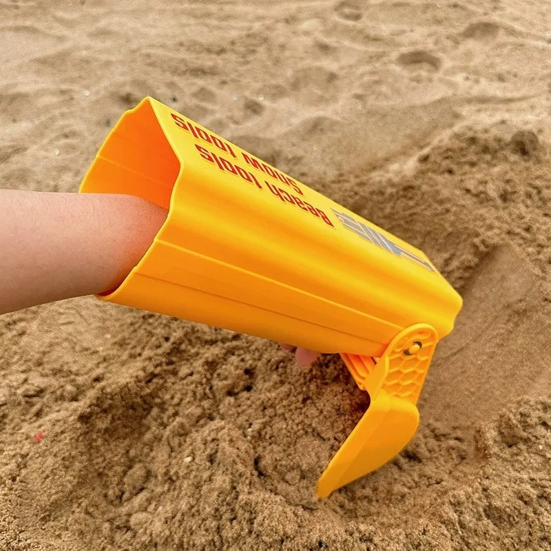 Red kids' handheld sand excavator toy for outdoor beach play, enhancing motor skills.