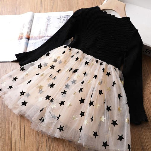 Close-up of star mesh print fabric on a long sleeve girls' party dress.
