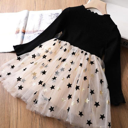 Close-up of star mesh print fabric on a long sleeve girls' party dress.