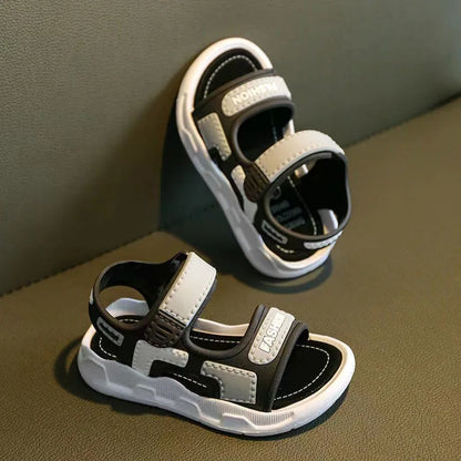 Close-up of pink children's footwear, showing textured non-slip sole and hook and loop closure.