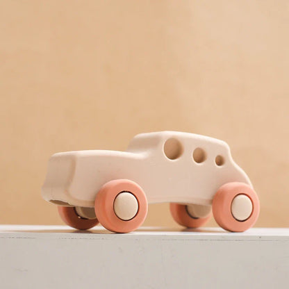 Baby chewing on a red silicone car teether, promoting healthy oral development