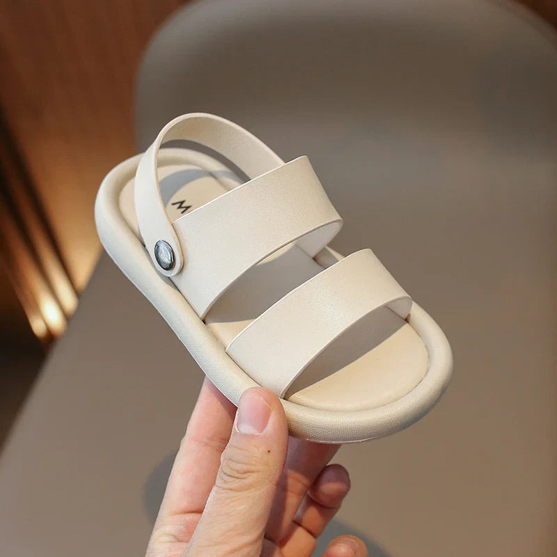 Close-up of a child's foot in a pink slip-on sport sandal, highlighting adjustable straps & breathable material.