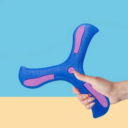 Red soft-grip kids boomerang toy in flight against a blue sky, perfect for outdoor active play.