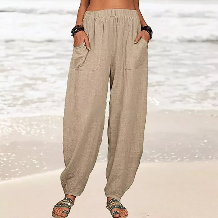 Model wearing comfortable white wide-leg beach pants with an elastic waist, ideal for resort wear.