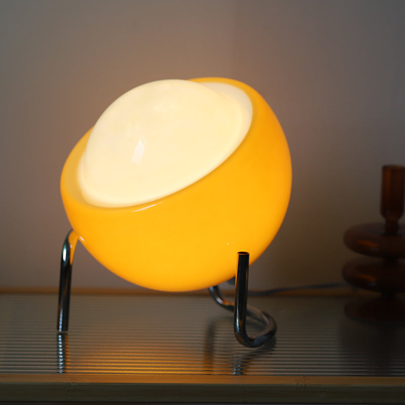 Soft ambient light from a retro glass orb table lamp. Enhances any room's decor.