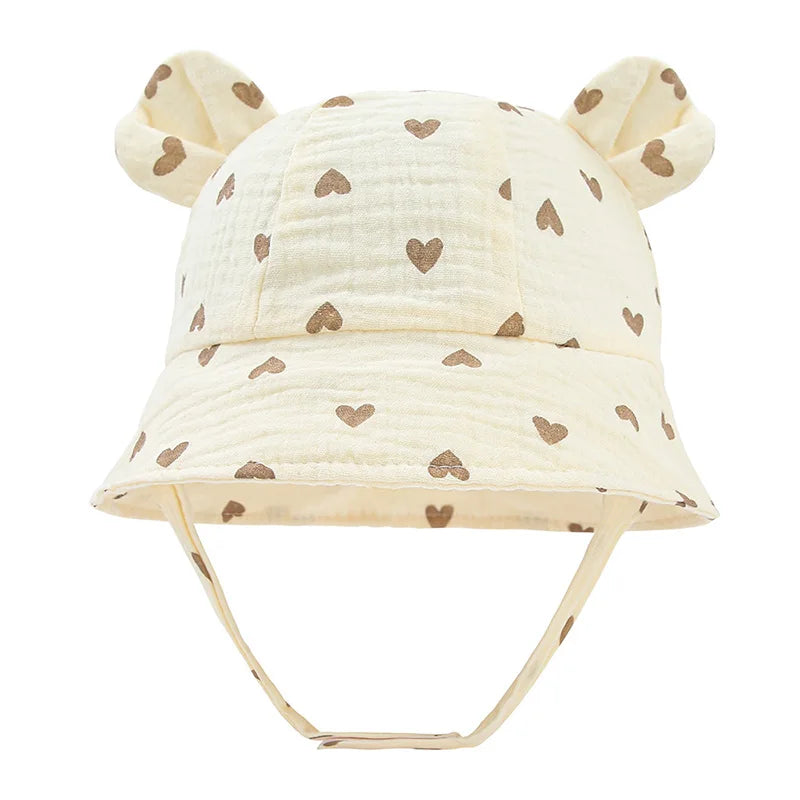 Toddler sun protection hat, reversible cotton bucket design, with cute khaki heart print.