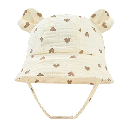 Toddler sun protection hat, reversible cotton bucket design, with cute khaki heart print.