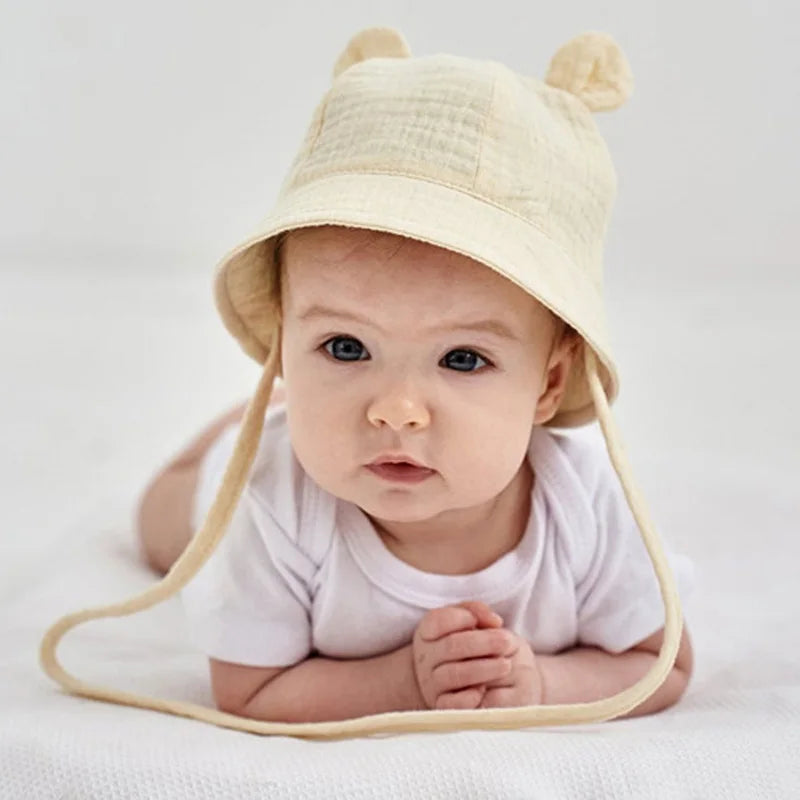 Adjustable and reversible cotton baby hat, khaki heart print, providing UPF sun protection.