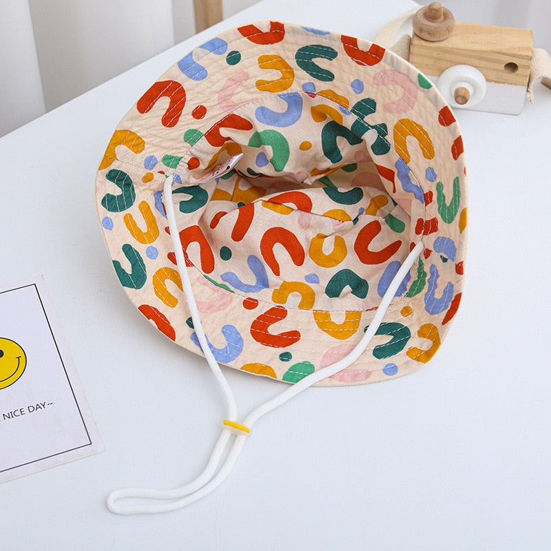 Infant cotton sun hat with chin strap, reversible design ensuring secure fit and sun safety