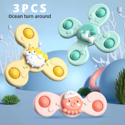 Happy baby reaching for a spinning suction toy, part of a fun and safe bath toy collection