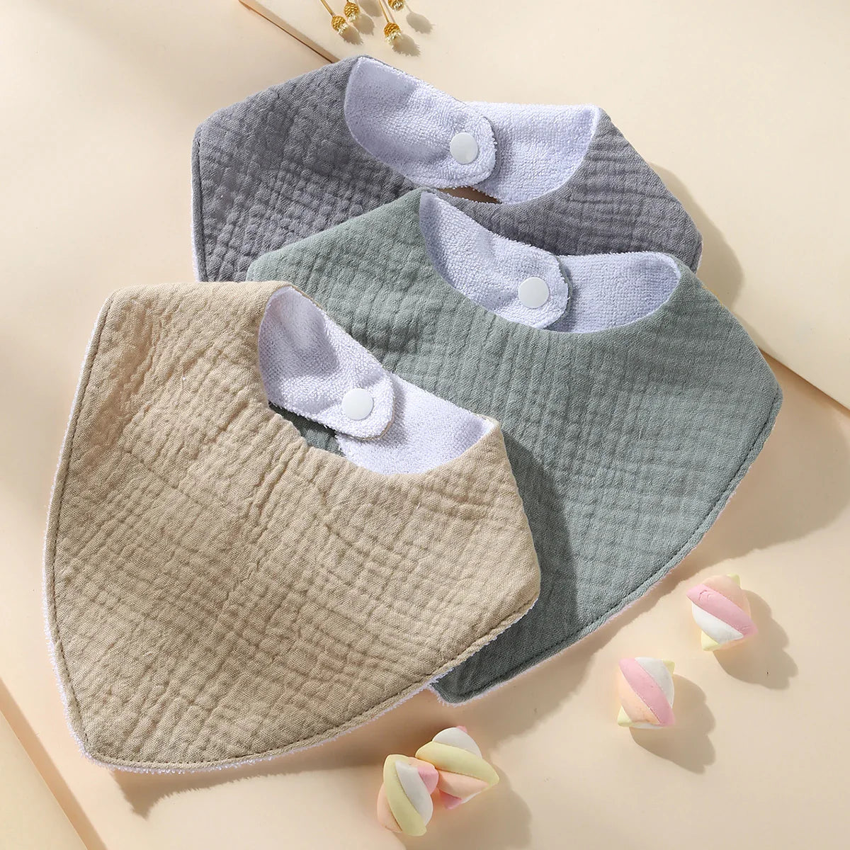 Close-up of a waterproof muslin cotton baby bib, featuring soft texture & adjustable snap for infant care.