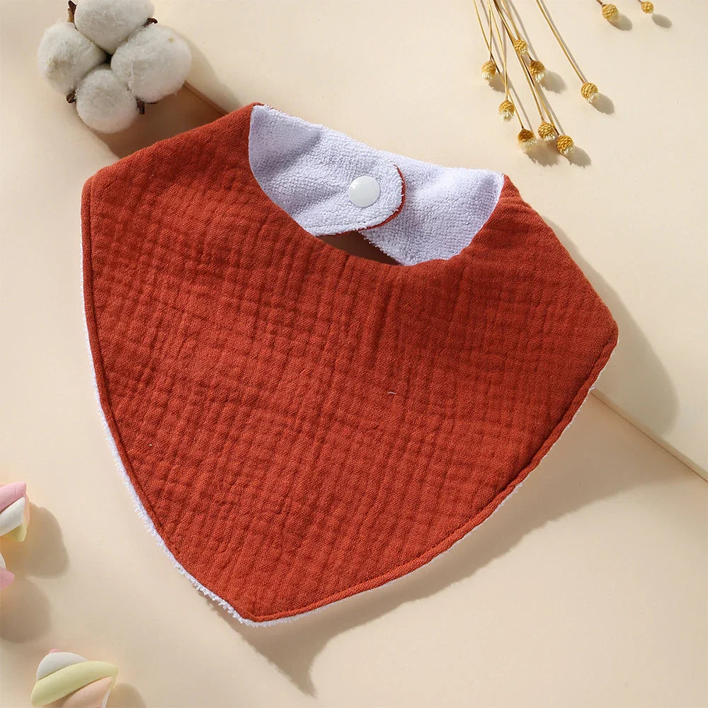 Stack of three neatly folded waterproof muslin cotton baby bibs, ready for daily feeding essentials.