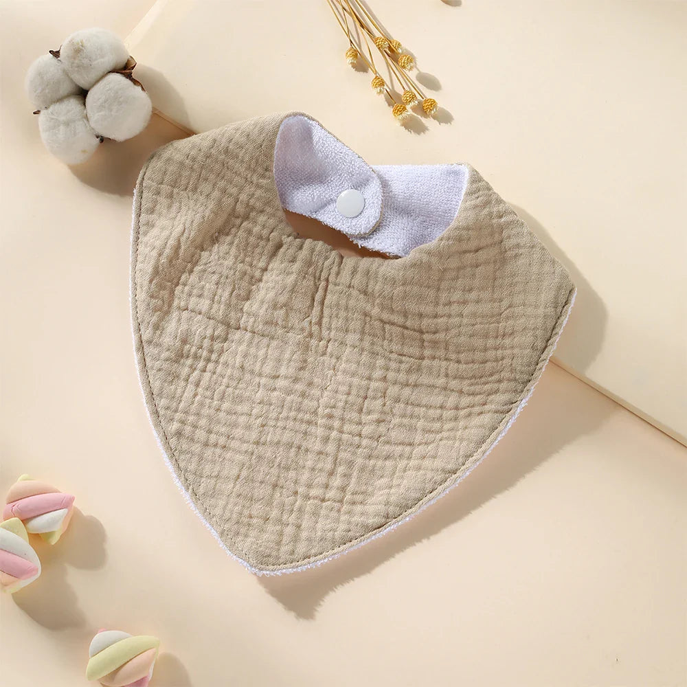 Detail shot of the adjustable snap closure on a waterproof muslin cotton baby bib, for infant comfort.
