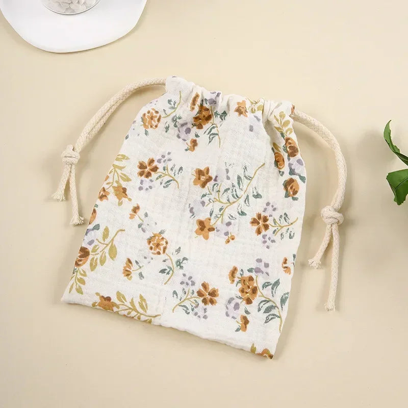 Set of different sized natural cotton bags for baby storage, eco-friendly travel organizers.