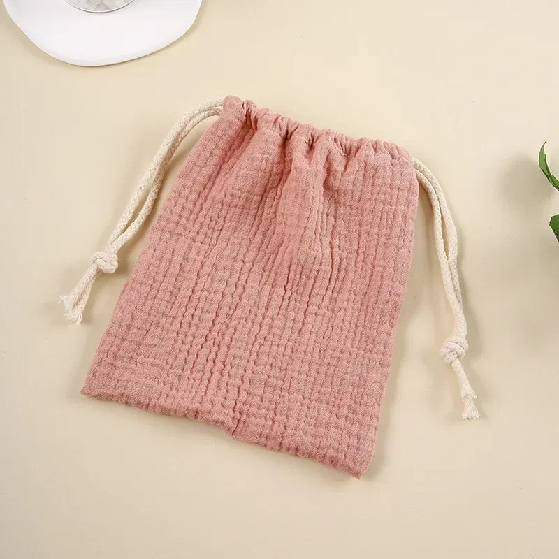Natural cotton baby accessories organizer, drawstring pouch design for easy access.
