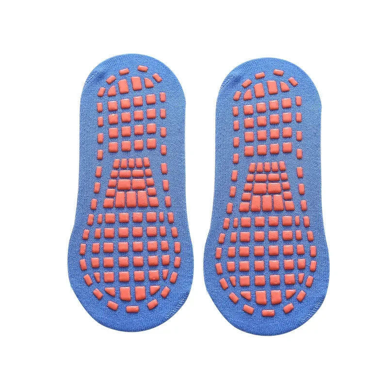 Adult hand holding a pair of black anti-slip trampoline socks, highlighting the durable cotton material.