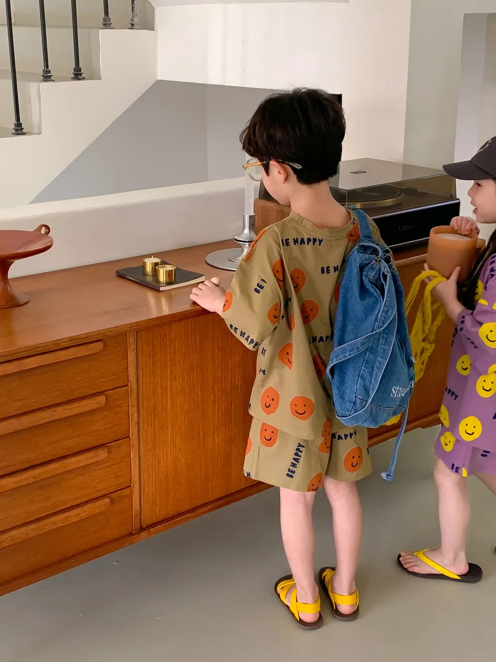 Casual kids' fashion set with a cheerful yellow smiley face on a blue short-sleeved t-shirt.