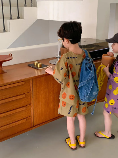 Casual kids' fashion set with a cheerful yellow smiley face on a blue short-sleeved t-shirt.