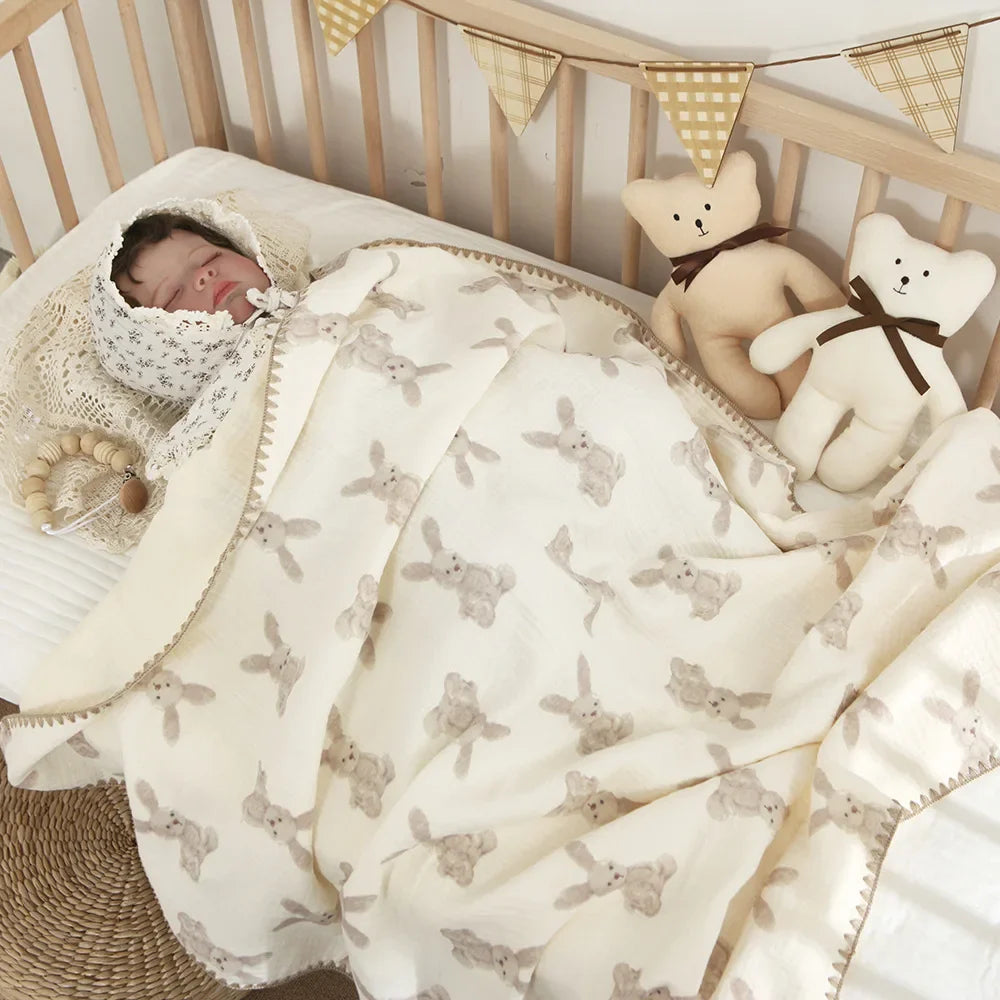Baby peacefully sleeping in a cozy white 4-layer cotton swaddle blanket for nursery comfort