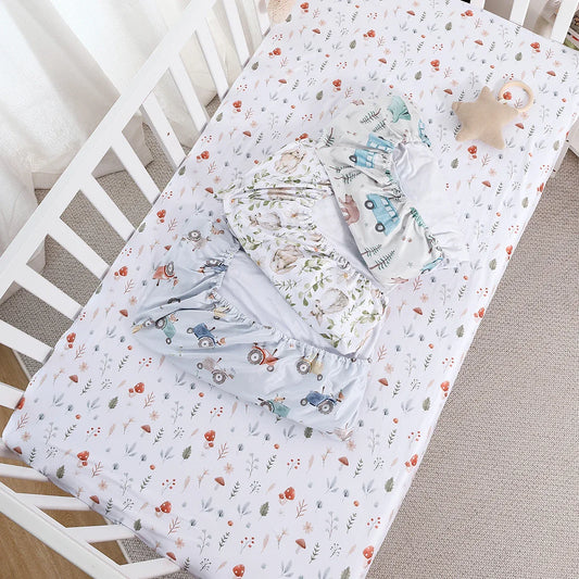 Soft baby crib sheet with playful cartoon animal print, breathable cotton for nursery.