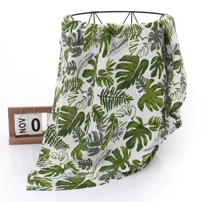 Bamboo cotton muslin swaddle blanket in a cute pattern, folded neatly for a baby shower gift