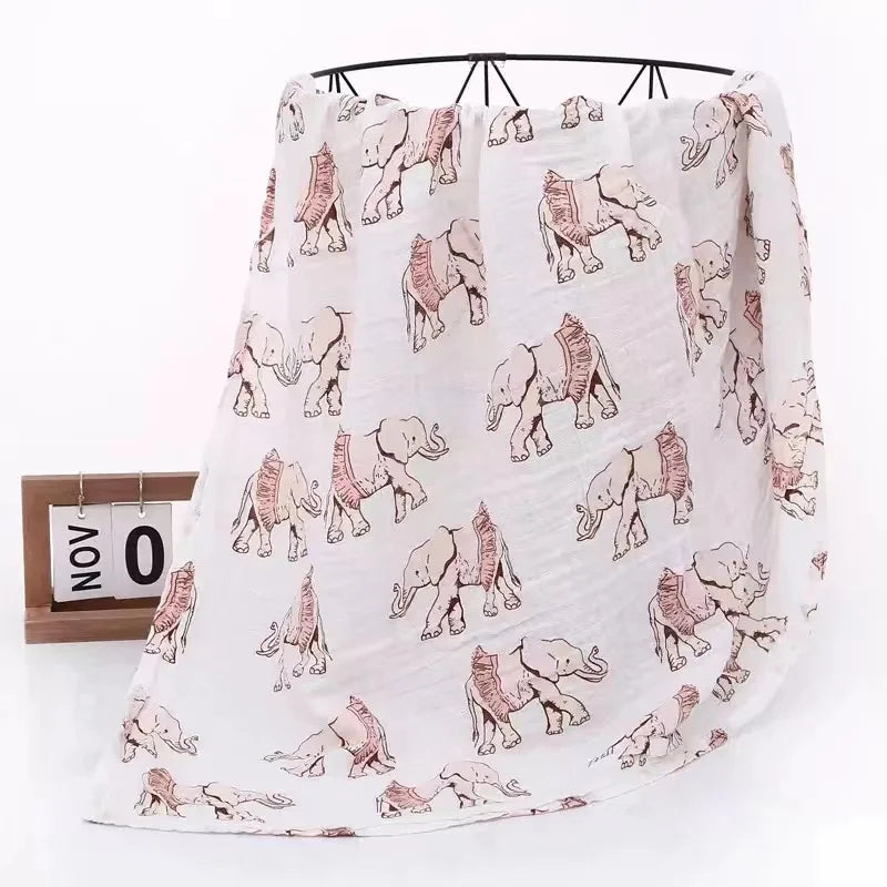 Infant sleeping soundly, partially covered by a gentle bamboo cotton muslin swaddle wrap
