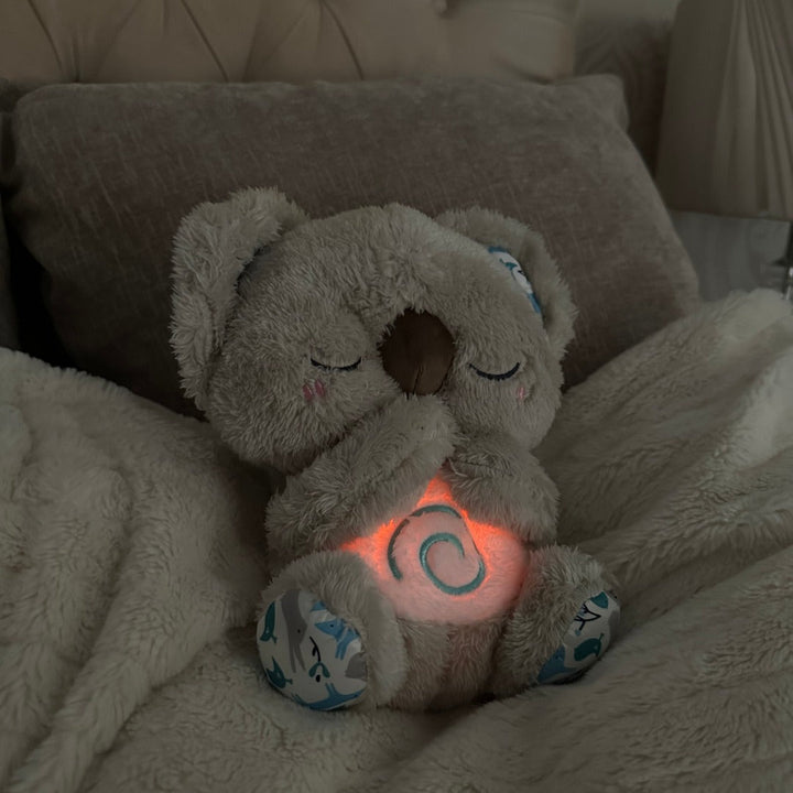 Koala plush sleep companion for babies & toddlers, offers anxiety relief, rhythmic breathing & soft light for bedtime.