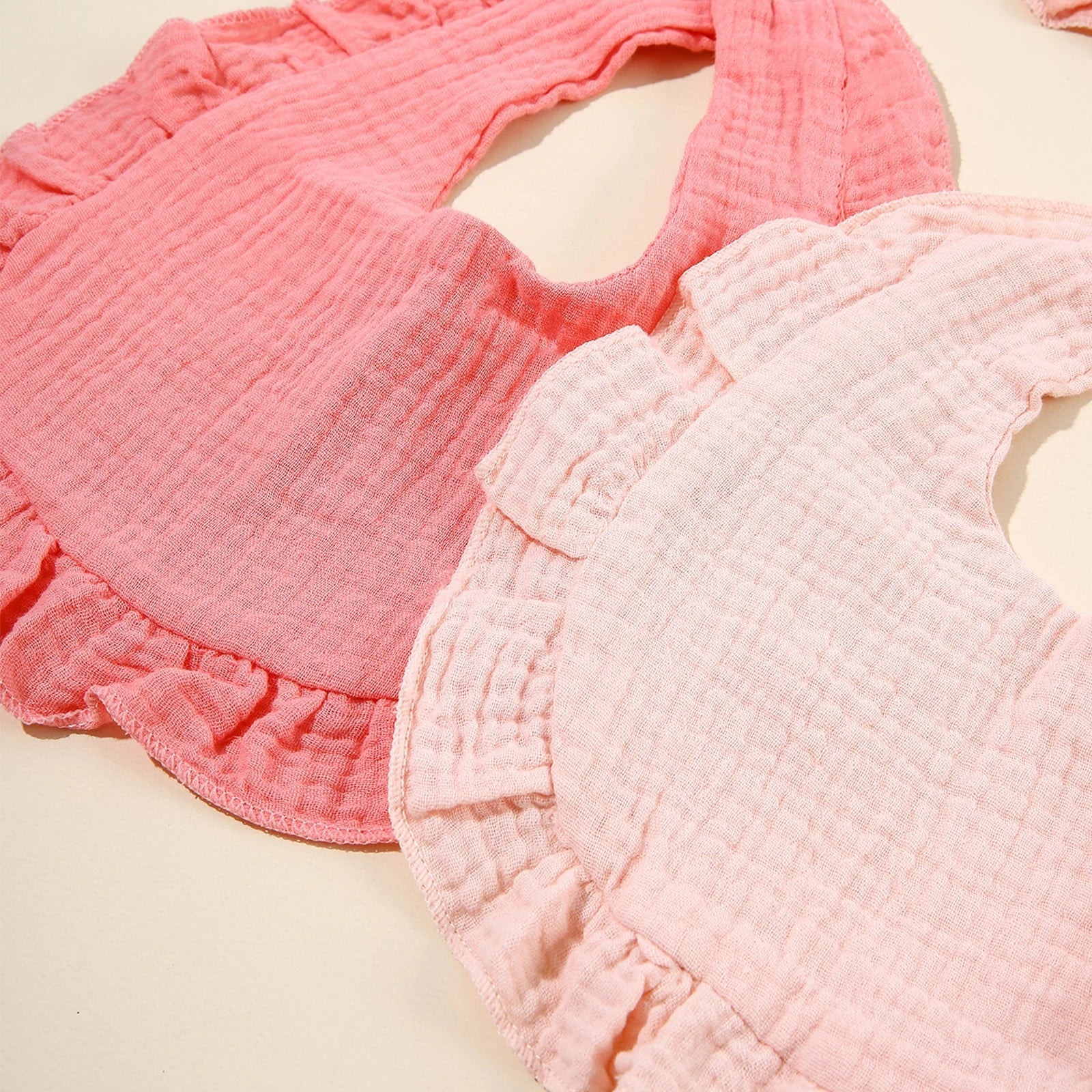 Close-up of a baby's cotton feeding bib, showcasing soft fabric texture, great for drool and meals.