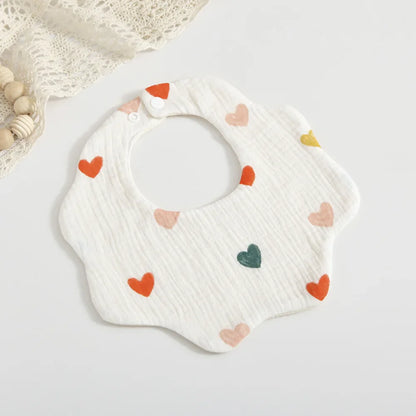 Detail shot of the petal print on a baby feeding bib, showing the vibrant colors & soft cotton material