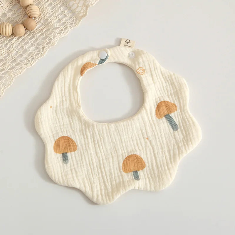Top-down view of a baby's cotton petal print feeding bib, displaying the full charming pattern