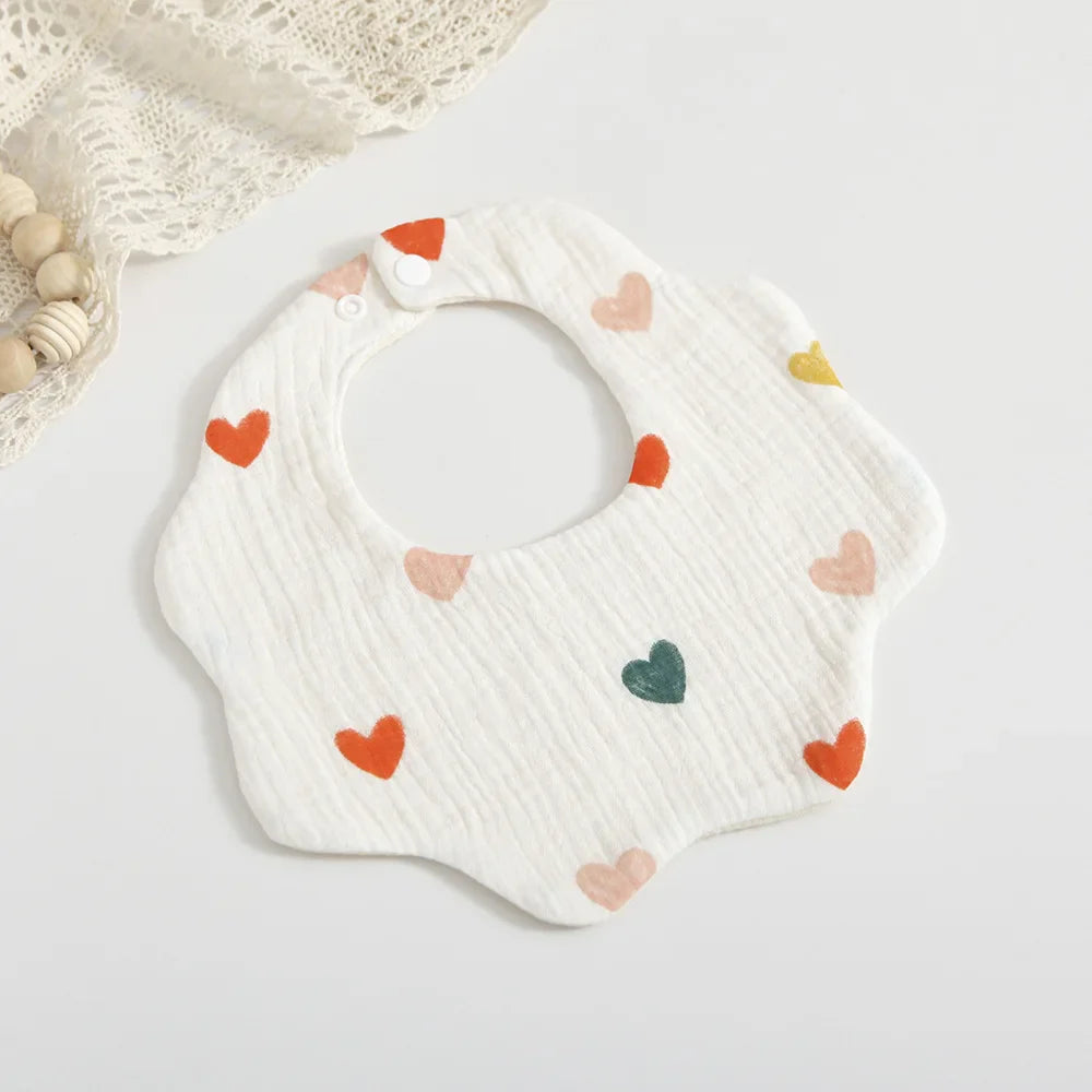 Baby wearing a cute cotton petal print dribble bib, keeping clothes clean during feeding, comfortable & stylish
