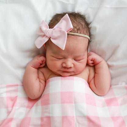 Baby swaddle wrap and hat in stylish plaid, designed for warmth and snug fit on infants.