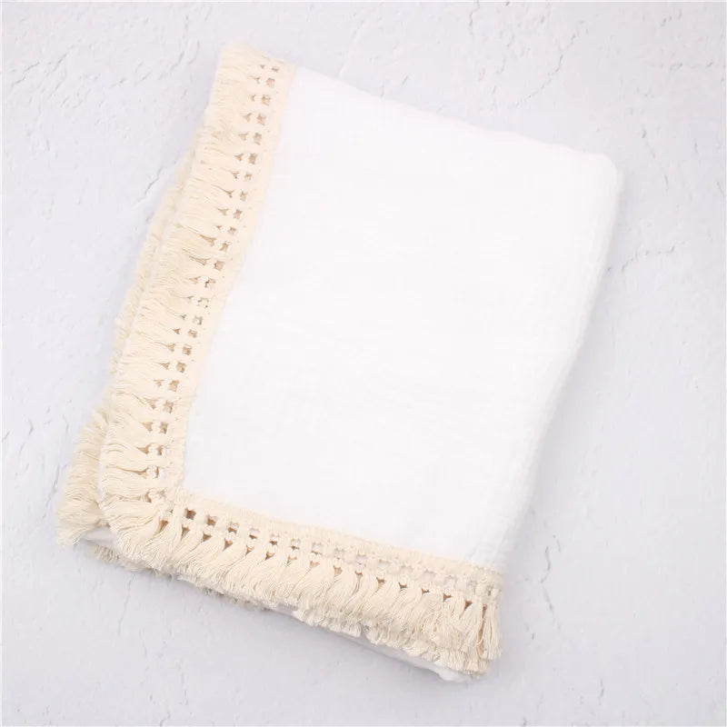 Newborn receiving wrap in breathable cotton, featuring elegant tassels, perfect for swaddling and comfort